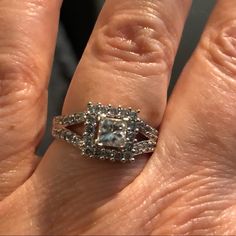 a woman's hand with a diamond ring on top of her finger, and the engagement band