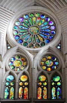 an ornate stained glass window in the inside of a church with pews and windows