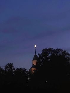 the moon shines brightly in the night sky over a church steeple and trees