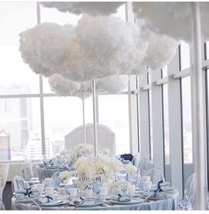 a table set up with blue and white linens for a wedding reception at the top of a skyscraper