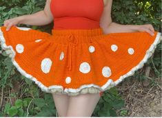 a woman wearing an orange and white crochet skirt with polka dots on it