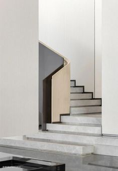 there is a staircase leading up to the second floor in this modern house with white walls and marble floors