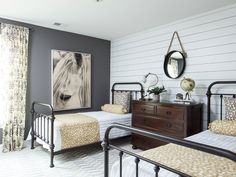 a bedroom with two twin beds and a painting on the wall above them, along with a dresser