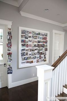 a white staircase with pictures hanging on the wall and wooden banisters next to it