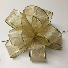 a gold colored bow on a white surface