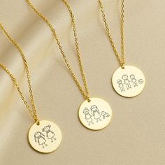 three personalized necklaces with children's drawings on them