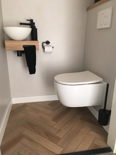 a white toilet sitting inside of a bathroom next to a wall mounted faucet