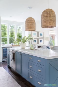 a kitchen with blue cabinets and an island in the middle is featured on instagram