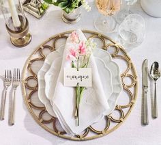 a place setting with napkins, silverware and flowers