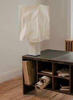 a white paper bag sitting on top of a wooden table next to a book shelf