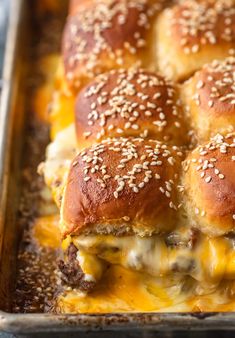 cheeseburger sliders in a baking pan with sesame seeds