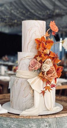 a white wedding cake with orange flowers on top