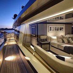 the interior of a luxury yacht with wooden flooring and walls that have been lit up at night