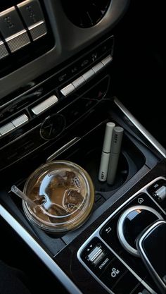 the interior of a car with an electronic device and coffee cup on the dash board