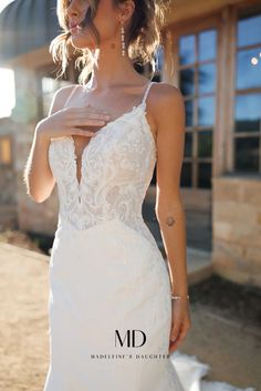 a woman in a white wedding dress posing for the camera with her hand on her hip