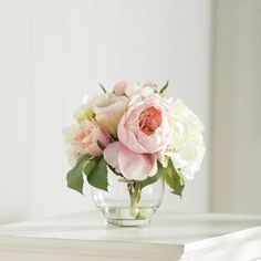 a glass vase filled with pink and white flowers