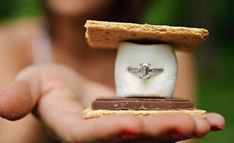 a person holding a piece of food with a ring in it's middle and a chocolate bar on top