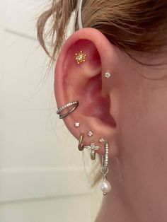 a woman's ear with three different types of piercings