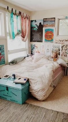 a bedroom with pictures on the wall and an old suitcase in front of the bed