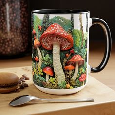 there is a coffee mug with mushrooms on it next to a spoon and cup holder