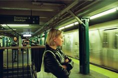 a woman is waiting for the subway to arrive