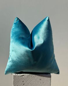 a blue pillow sitting on top of a cement block