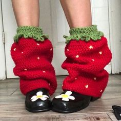 the legs and ankles of a woman wearing red knitted socks with flowers on them