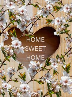 a heart shaped hole with the words home sweet home in it surrounded by white flowers