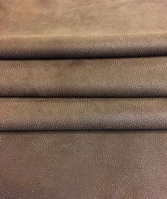 three pieces of brown leather are stacked on top of each other in this close up photo