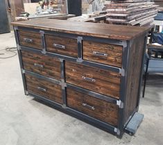 a large wooden dresser sitting inside of a room next to a pile of wood planks