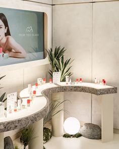 a woman's skin care products displayed in front of a large poster on the wall