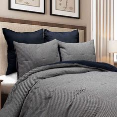 a bed with black and white checkered comforter set next to a night stand