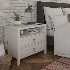 a bedroom with a bed, nightstand and brick wall in the backround area