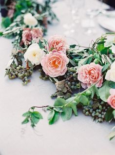 flowers and greenery are laid out on the table to be used as centerpieces