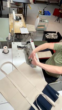 a woman is working on a project in a room with many tables and desks