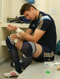 a man sitting on the floor with bandages around his ankles