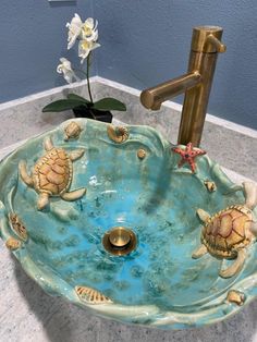 a bathroom sink with sea turtle designs on it