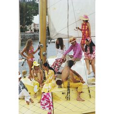 a group of people sitting on top of a sailboat in the water with other people standing around