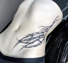 a woman's stomach with a tree branch tattoo on her lower back and side