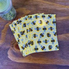 two bees on yellow and blue napkins next to a jar of green pesto