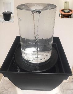 a glass with water in it sitting on top of a black tray