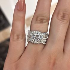 a woman's hand with a diamond ring on top of her wedding band and two diamonds in the middle