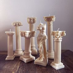 there are many candles that have statues on the top and bottom of them in different shapes