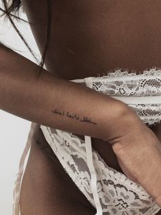 a woman with a tattoo on her left arm and the words in arabic written on her right arm