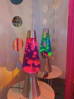 three colorful vases sitting on top of white tables