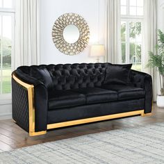 a black velvet couch with gold trim in a living room