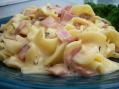 pasta with ham and cheese on a blue plate