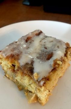 a piece of cake on a plate with icing drizzled over it