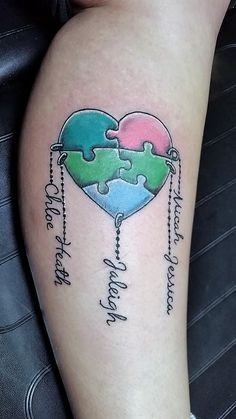 a heart shaped puzzle piece tattoo on the leg with words written below it and two pieces missing