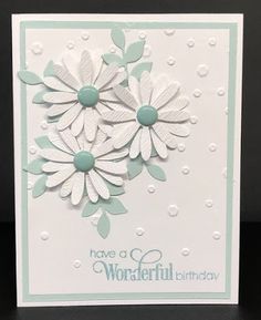 a card with white flowers on it and the words have a wonderful birthday written in blue